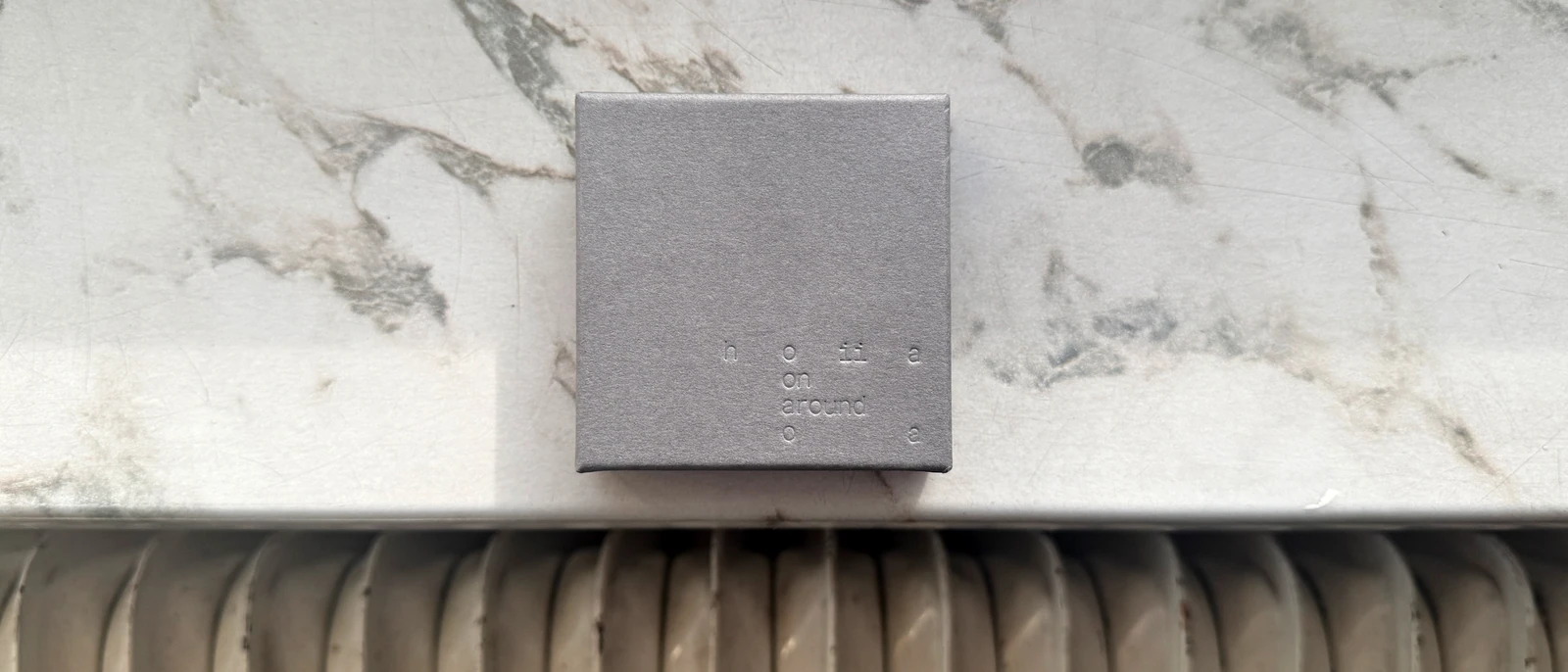 Silver-grey Hoiia jewellery box with embossed lettering.