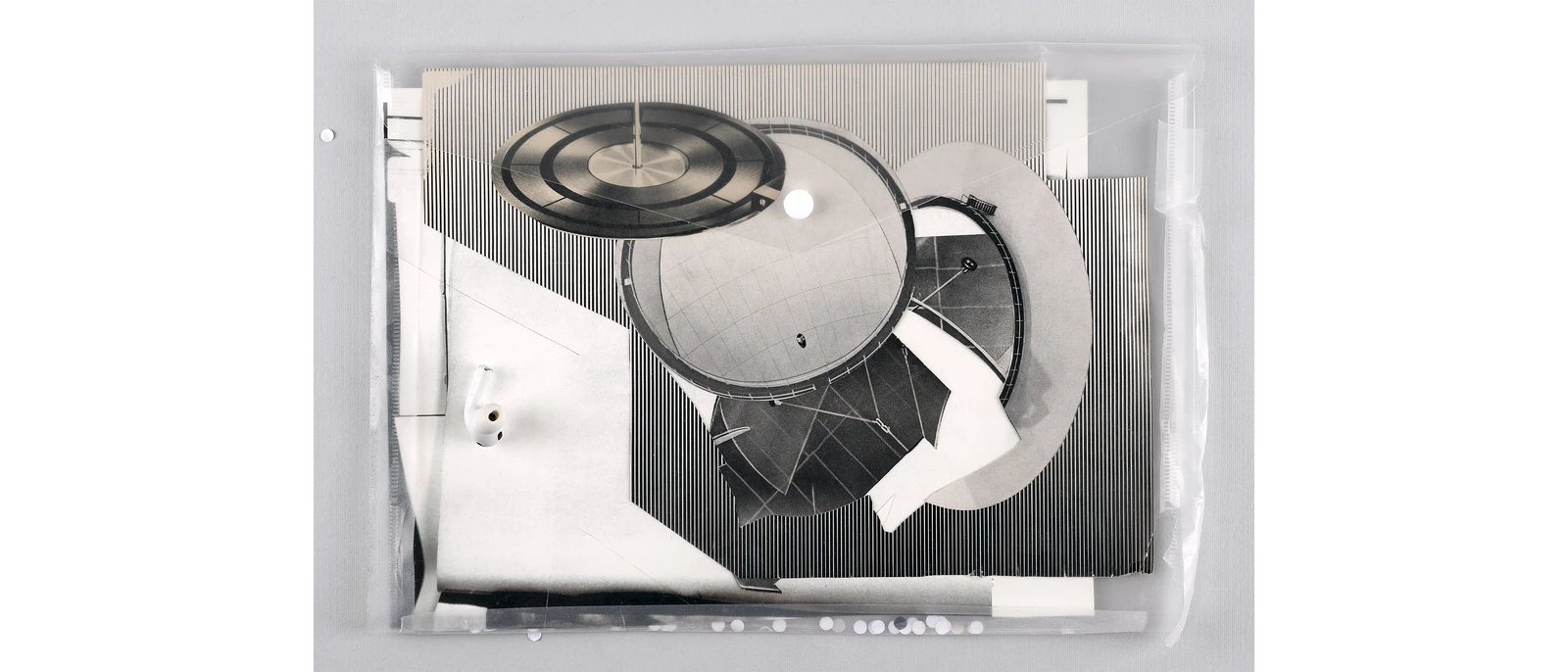 Layered black-and-white machine imagery arranged inside a transparent tray.