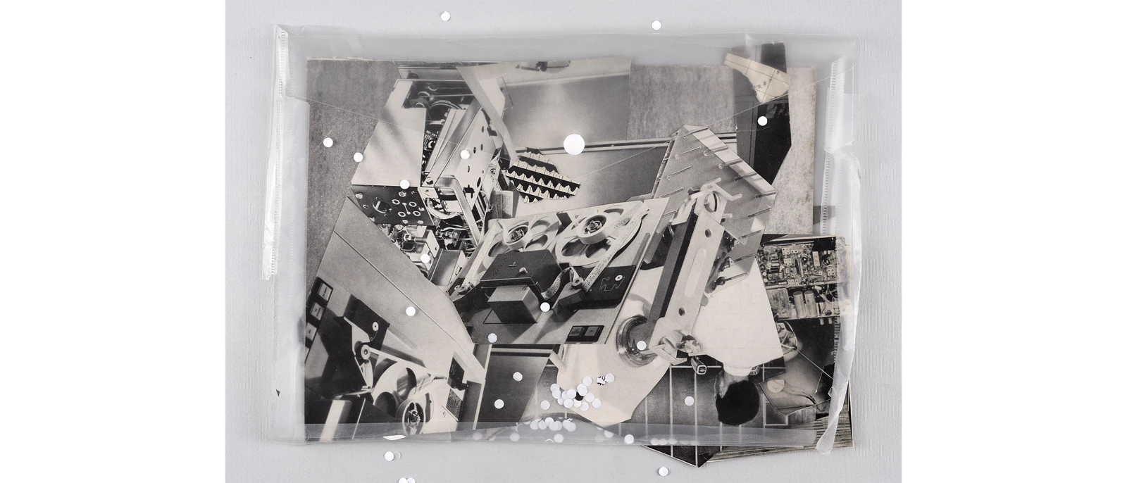 Layered technical diagrams and circular patterns arranged inside a transparent tray.